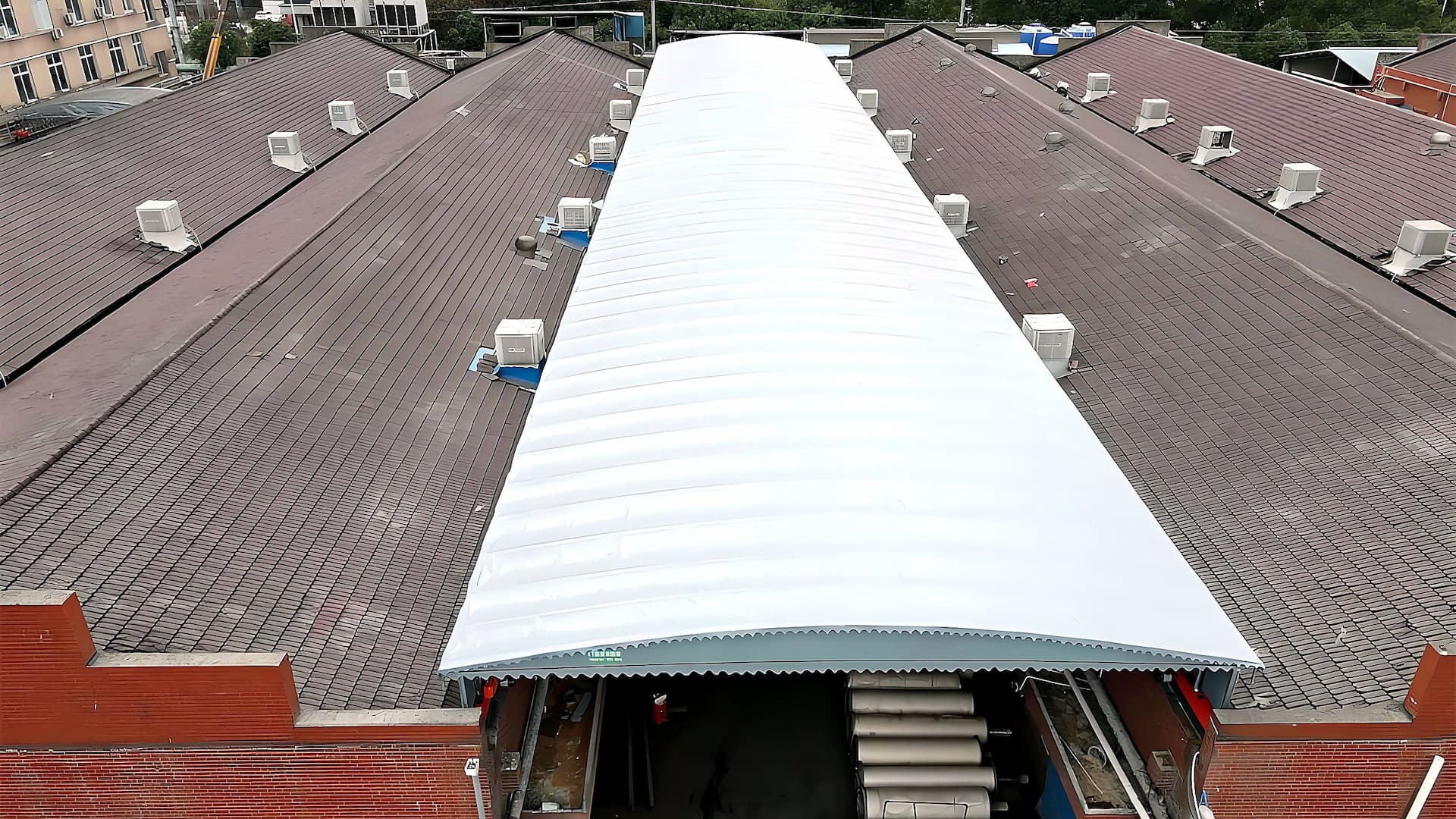 Factory storage yard — white arc-roof retractable canopy aerial view